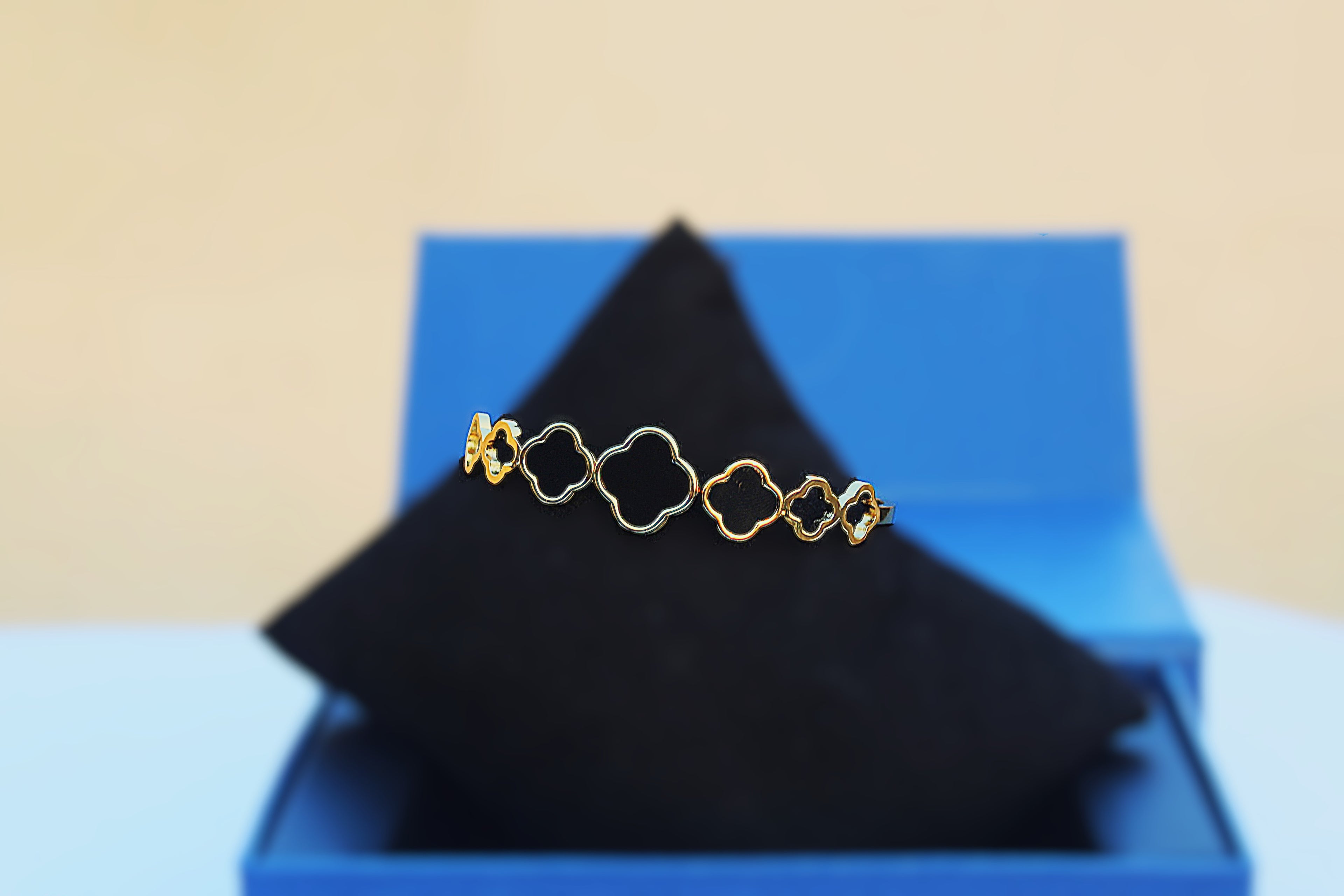 Modern Elegance: Stainless Steel Bangle with 1 Carat Gold Polish and Black Clover Design