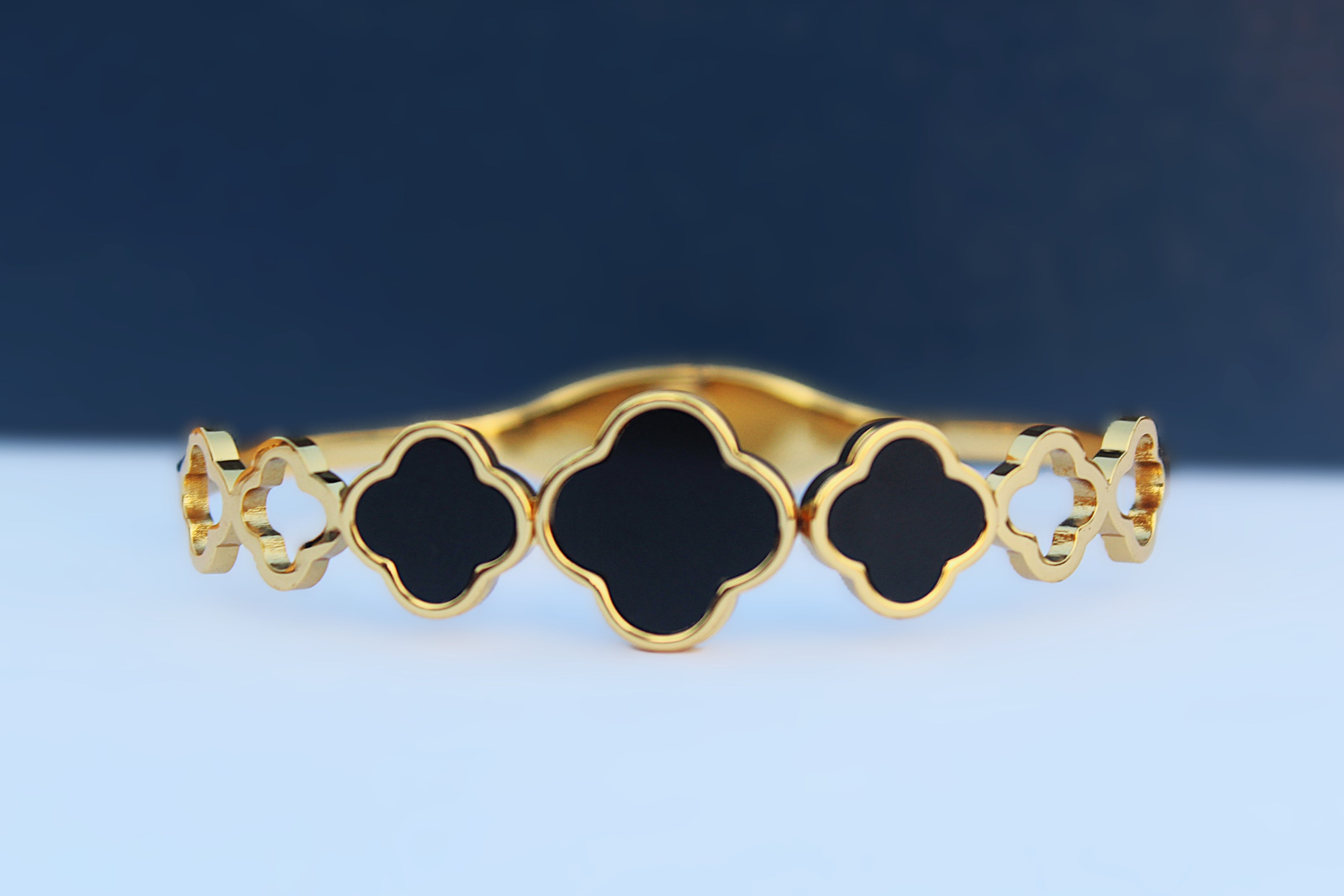 Modern Elegance: Stainless Steel Bangle with 1 Carat Gold Polish and Black Clover Design
